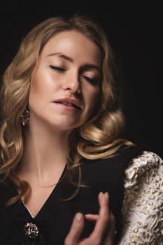 Beautiful blonde in a dress, portrait on a black background.