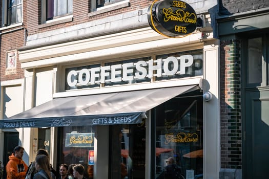 AMSTERDAM, THE NETHERLANDS - APRIL 15, 2019: Coffee shop window with showcase and people