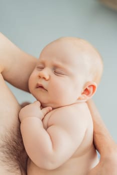 A baby peacefully falls asleep in his father's arms, skin-to-skin. A heartwarming and intimate moment of love, bonding, and parenthood, showcasing the deep connection between father and child.