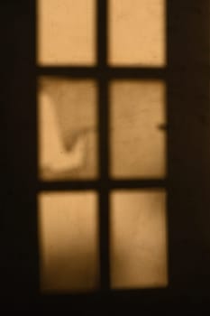 Warm light filters through windowpanes, casting silhouettes that evoke mystery and the promise of hidden narratives.