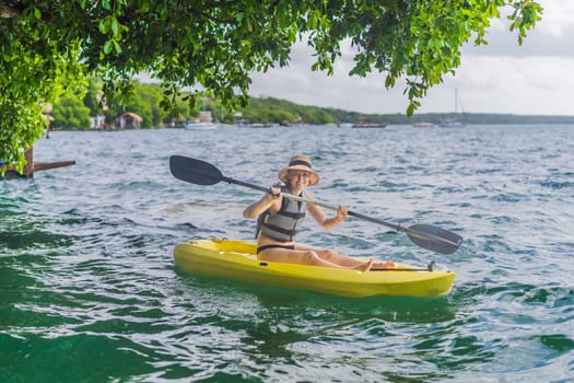 Woman kayaking on Bacalar Lake in Mexico. Adventure tourism in Quintana Roo, outdoor exploration, and water activities concept.