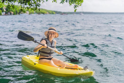 Woman kayaking on Bacalar Lake in Mexico. Adventure tourism in Quintana Roo, outdoor exploration, and water activities concept.