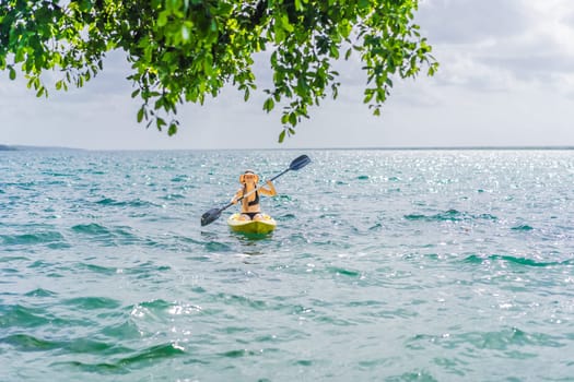 Woman kayaking on Bacalar Lake in Mexico. Adventure tourism in Quintana Roo, outdoor exploration, and water activities concept.