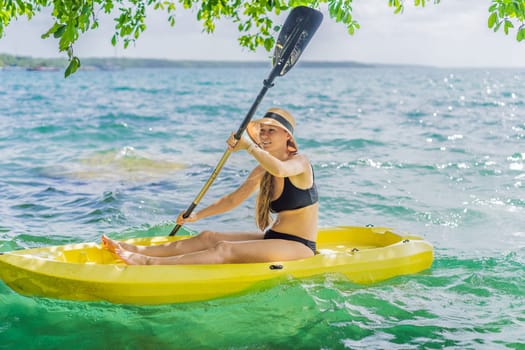 Woman kayaking on Bacalar Lake in Mexico. Adventure tourism in Quintana Roo, outdoor exploration, and water activities concept.