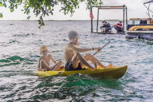 Father and son tourists kayaking on Bacalar Lake in Mexico. Adventure tourism in Quintana Roo, outdoor exploration, and water activities concept.