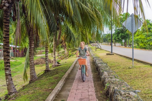 Female tourist cycling through the charming village of Bacalar, Mexico. Quintana Roo travel, scenic bike paths, and eco-friendly exploration concept.