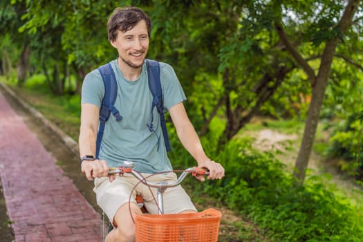 Man tourist cycling through the charming village of Bacalar, Mexico. Quintana Roo travel, scenic bike paths, and eco-friendly exploration concept.