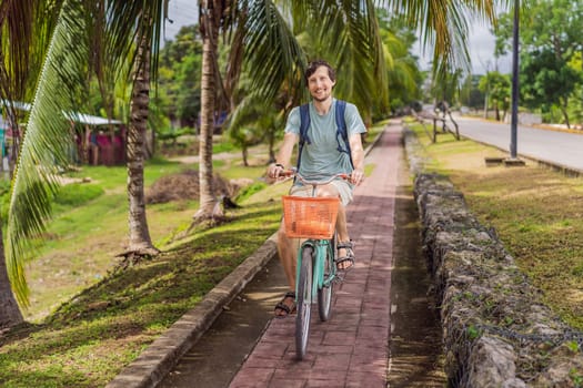 Man tourist cycling through the charming village of Bacalar, Mexico. Quintana Roo travel, scenic bike paths, and eco-friendly exploration concept.
