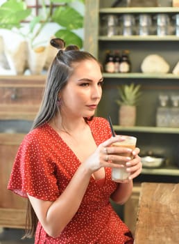Young woman  drinking ice coffee in a coffee shop