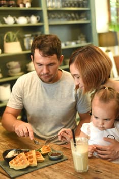 Family eating Belgium waffles in a cafe