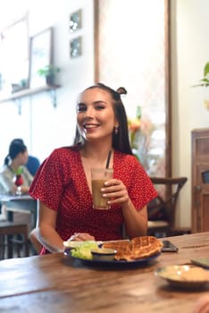 Young woman drinking ice coffee in a coffee shop