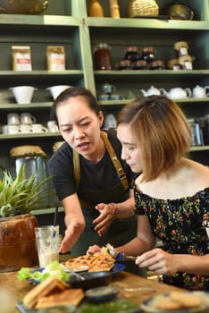 Vietnamese waitress served waffles to a caucasian woman