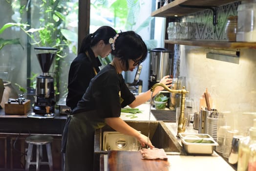 Vietnamese waitress getting ready an order in a coffee shop