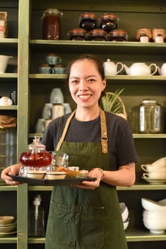 Vietnamese young woman serving tea in a coffee shop