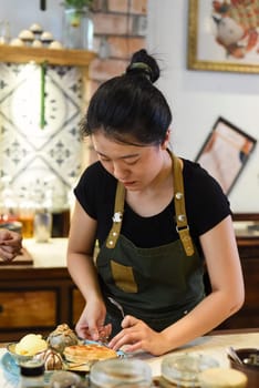 Vietnamese young waitress preparing home made ice cream for a customer
