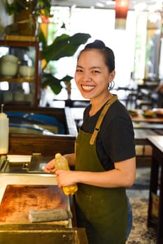 Vietnamese happy waitress working in a kitchen of a cafe