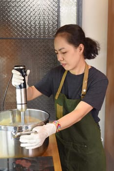 Young vietnamese woman stirs the avocado ice cream base