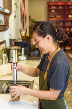 Vietnamese barista using a mixer for condensed milk in glass cup for preparing vietnamese coffee Cafe Sua