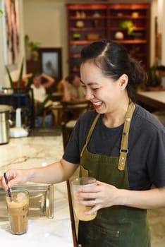 Vietnamese barista added ice and straw in vietnamese coffee Cafe SuaVietnamese barista added ice and straw in vietnamese coffee Cafe Sua