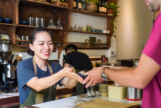 Vietnamese waitress serving ice cream for a customer in a coffee shop