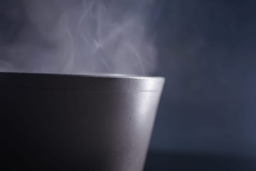 A bowl of soup emits steam, creating a cozy atmosphere in low light.