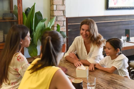Female best friends talking and eating in a cafe