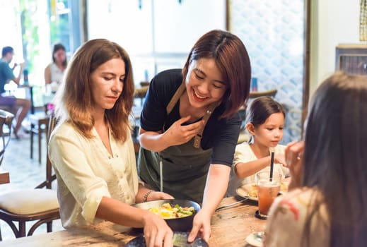 Vietnamese waitress cleaning table for customers in cafe showing vietnamese culture and politness