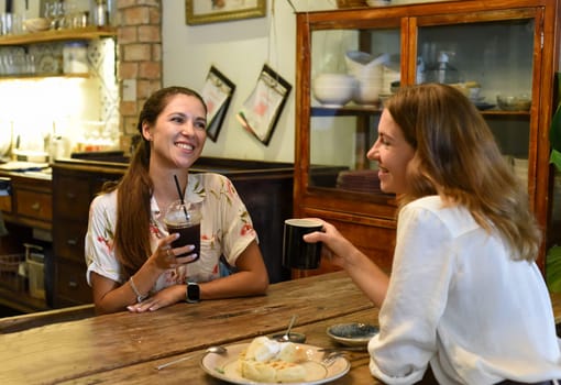 Two best friends talking and drinking coffee in a cafe