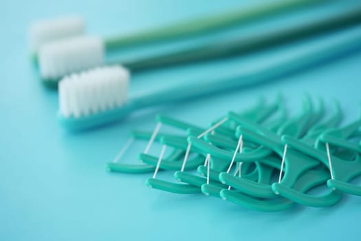 Various dental care tools arranged on a turquoise background.
