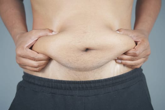 Person holds excess skin around the midsection, expressing concern.
