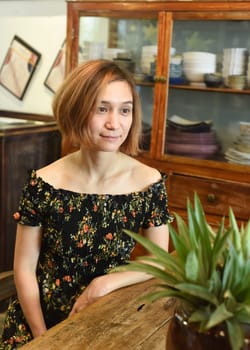 A young woman sitting at wooden table in a coffee house