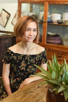 A young woman sitting at wooden table in a coffee house