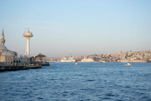 Boats navigate the tranquil waters while the sun sets over Istanbul.