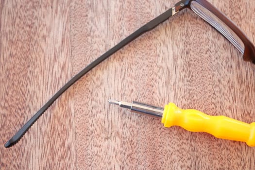 Tools and glasses on wooden surface ready for repair work.