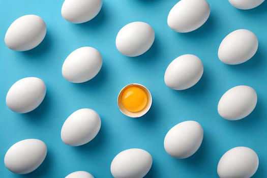 A group of white eggs scattered on a vibrant blue background, with one egg cracked open to reveal a bright yellow yolk, creating a minimalist, clean food composition.