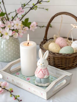 A charming Easter-themed setup with a bunny figurine, a lit candle, colorful eggs, and fresh spring branches. A perfect example of festive decoration for Easter.