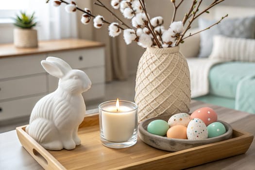 A cozy tabletop setting featuring a white ceramic bunny, pastel Easter eggs, cotton flowers, and a candle, perfect for creating a festive, spring atmosphere.