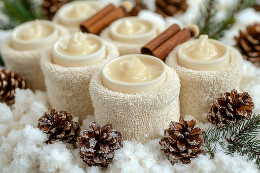 A cozy winter spa arrangement includes natural candles surrounded by pine cones, towel wraps, and fresh greenery, creating a serene atmosphere.