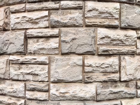 Rough textured stone wall displays a mix of light and dark shades, providing an ideal backdrop for custom text and designs.