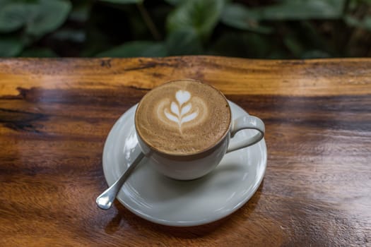 Coffee in white cup on wood table in coffee shop
