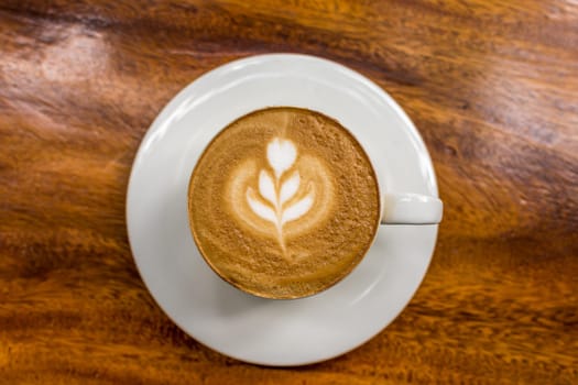 Coffee in white cup on wood table in coffee shop