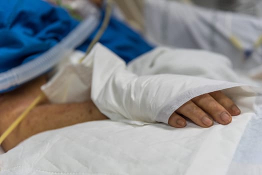 Patient in the hospital with incontinent pad and elderly patient hand