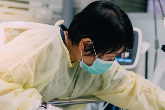 Asian women 40s years old is a patient relative taking care of the CRE. or VRE. infected elder patient 80s years old on patient bed in intensive care unit (ICU.) room at hospital.