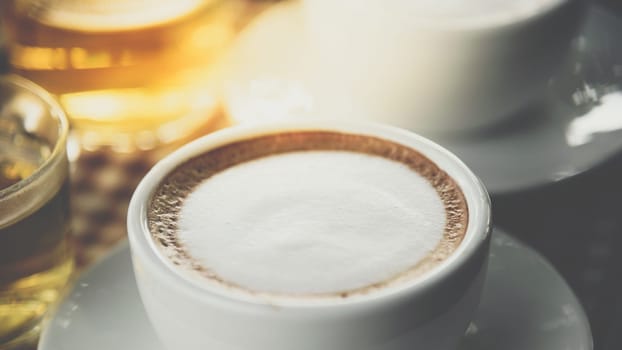 Coffee drink in the white coffee cup on wood table with tea for serve to customers at coffee shop cafe or restaurant