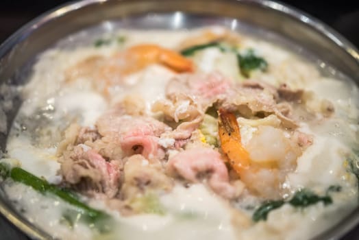 Cooking food by put a flesh beef, pork, egg and vegetable in to a hot pot for make a sukiyaki or shabu at japanese shabu buffet restaurant