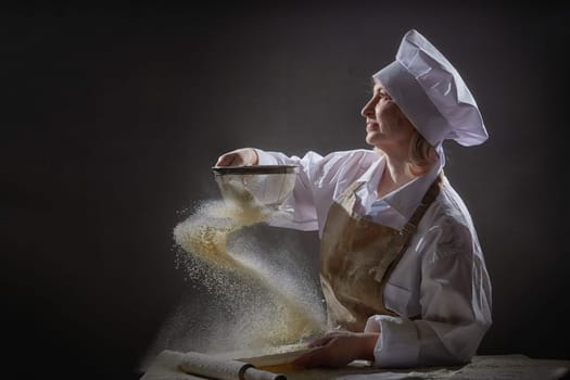 An elderly woman sifts flour with joy and creativity while engaging in a humorous kitchen photo shoot, showcasing her culinary skills.