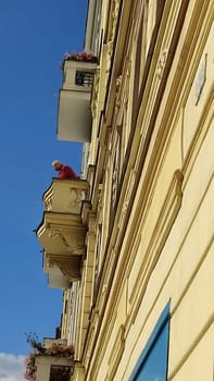 October 15 2024 Prague Czech Republic Europe Man leaning balcony architecture street building blue sky wall . High quality photo editorial