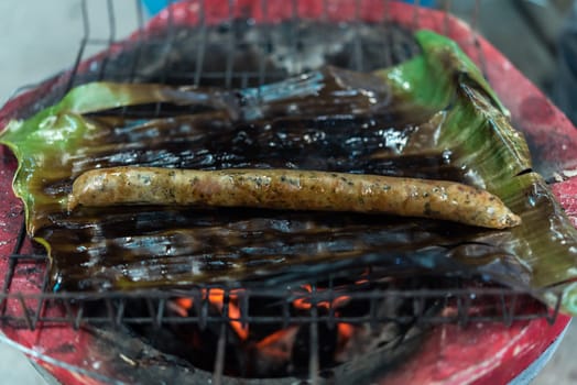 Roasted or Grilled Notrhern Thai Spicy Sausage (Sai Aua) for sale at Thai street food market or restaurant in Thailand