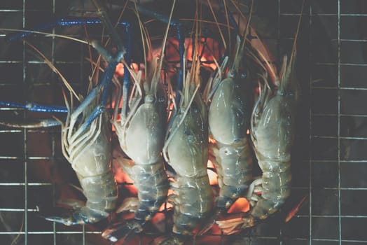 Grilled shrimp (Giant freshwater prawn) grilling with charcoal for sale at Thai street food market or restaurant in Bangkok Thailand