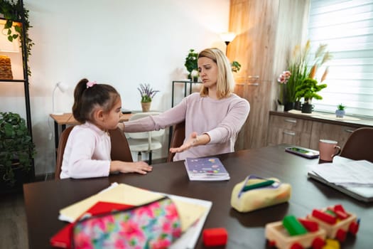 A mother and daughter engage in a deep conversation at their cozy dining table.